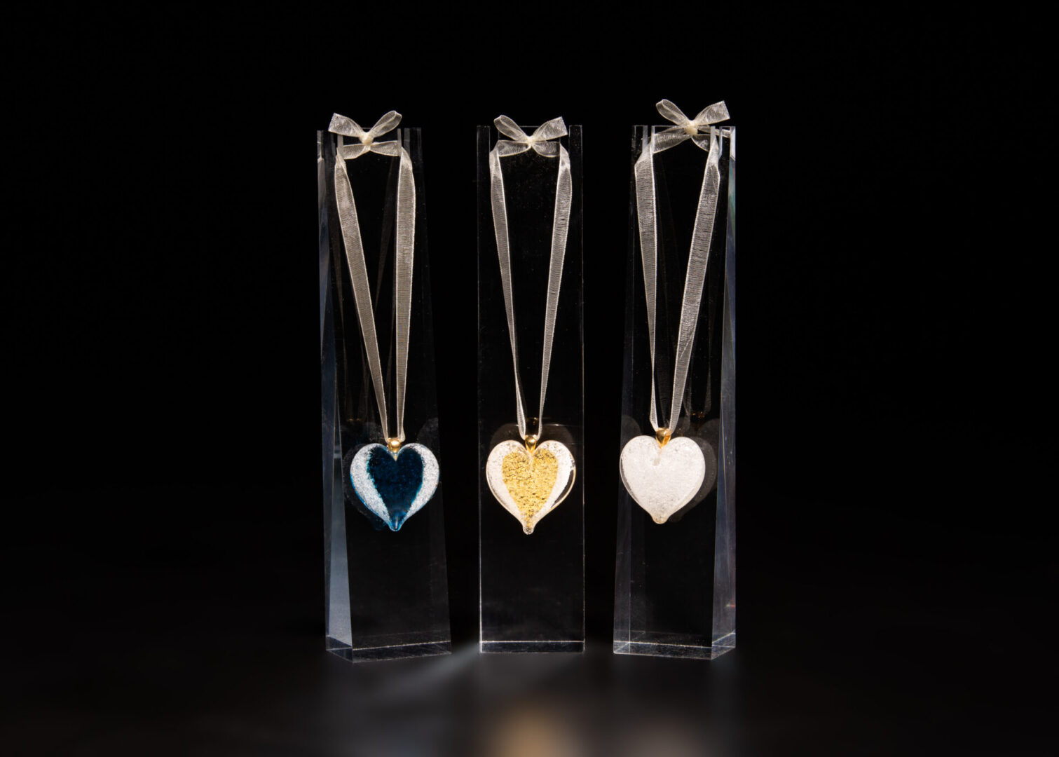 Angel Wings cremation jewelry pendants beautifully displayed on optional acrylic stands